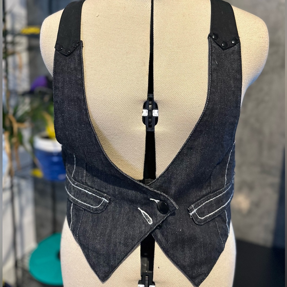 COPY - black denim features a deep V-neckline, front button closures, two front…